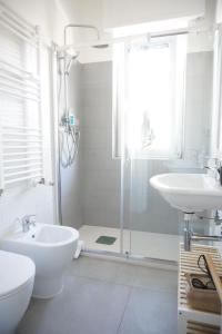 biała łazienka z prysznicem i umywalką w obiekcie Ostia Sunset w mieście Lido di Ostia