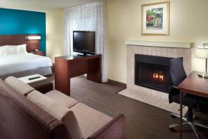 Residence Inn by Marriott Nashville Airport في ناشفيل: غرفة فندقية بها سرير وموقد