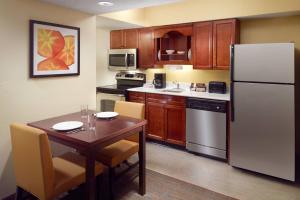 a kitchen with a table and a white refrigerator at Residence Inn by Marriott Nashville Airport in Nashville