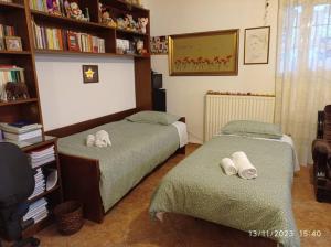 two beds in a room with bookshelves at Επικούρειος Ξενώνας 