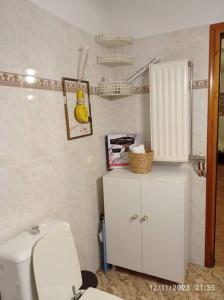 a bathroom with a toilet and a white cabinet at Επικούρειος Ξενώνας 