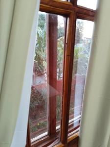 a window in a room with a view of a garden at Apartment El sueño de Julieta in Puerto Iguazú