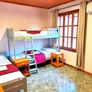 a room with two bunk beds and two tables at Apartment El sueño de Julieta in Puerto Iguazú