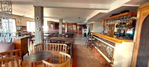 a restaurant with tables and chairs and a bar at Meulen Hosteria y Apart in El Calafate