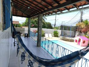um alpendre com uma rede de descanso e uma piscina em Casa Alto da Boa Vista - 3 quartos em Araruama