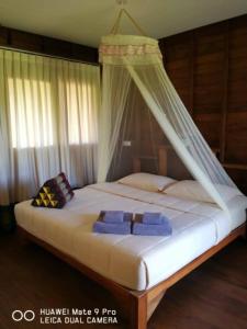 een slaapkamer met een hemelbed bij NammNatawn2 in Ko Yao Noi