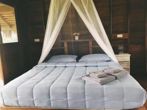 a bed with a canopy with two pillows on it at NammNatawn2 in Ko Yao Noi