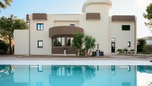 a house with a swimming pool in front of it at La Gigasuite - Design Villa at Sea with Spa & Pool in Taranto