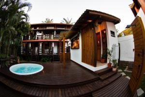 a wooden deck with a hot tub on a house at Morada da Xica in Guarda do Embaú