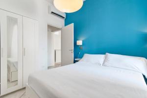 ein Schlafzimmer mit einem weißen Bett und einer blauen Wand in der Unterkunft Casa Arditi - Lecce Selection in Lecce