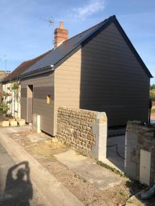 a house with a garage with a brick wall at La petite maison in Putanges-le-Lac
