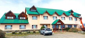a large house with a car parked in front of it at Meulen Hosteria y Apart in El Calafate