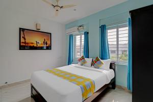 um quarto com uma cama grande com paredes e janelas azuis em OYO Nr Royal em Bangalore
