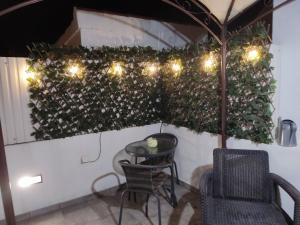 a patio with a table and chairs and lights at The Sunny Cottage in Faro