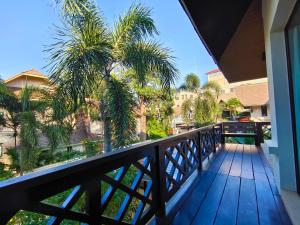 a balcony with a view of palm trees at Baan Natcha pool Villa 芭提雅市中心 泰国风情 别墅 网红 拍照 蜜月 轰趴派对 夜店 豪华 in Pattaya Central