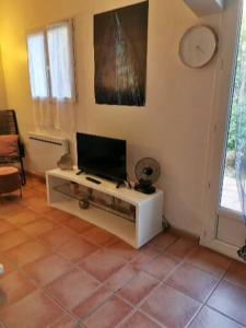 sala de estar con TV de pantalla plana en la pared en Le petit havre de Paix, en Toulon