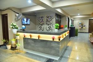 a lobby with a reception counter with potted plants at Hotel Wedlock Premium Medanta in Gurgaon
