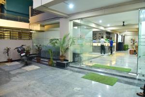 um lobby com vasos de plantas e pessoas em um edifício em Hotel Wedlock Premium Medanta em Gurgaon