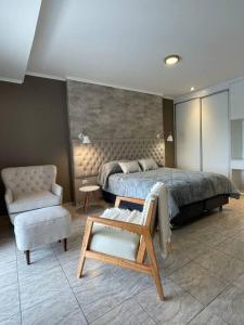 a bedroom with a bed and a chair and a couch at Bitcoins House Los Carpinchos Laguna Brava in Corrientes +9 photos