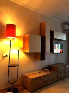 a living room with a lamp and a tv at Cozy flat in the middle of Tbilisi in Tbilisi City