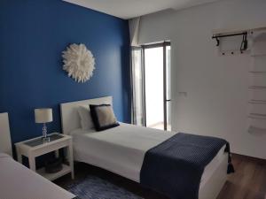 Schlafzimmer mit einem Bett mit blauer Wand in der Unterkunft The Old Town House in Faro