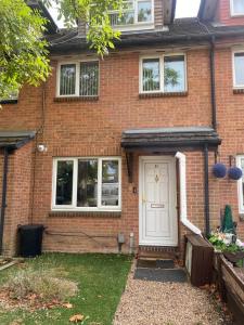a brick house with a white door at Lovely 1 bedroom flat in Chigwell