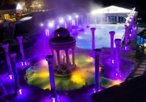 a fountain with purple lights next to a swimming pool at Apartmán v centre Žiliny in Žilina