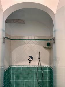 un bagno con doccia e piastrelle verdi di Casa Vacanze Il Libeccio a Positano Altre 37 foto