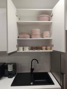 a kitchen with a sink and cups and plates at Encantador apartamento completo con dos habitaciones in Madrid