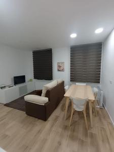 sala de estar con sofá, mesa y silla en Encantador apartamento completo con dos habitaciones, en Madrid
