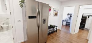 a kitchen with a stainless steel refrigerator in a room at Fantastic 3 bedroom next playa Las Américas & WIFI FREE in Playa Fañabe