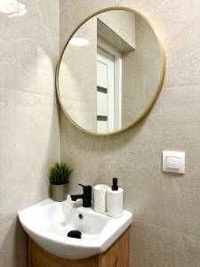 a bathroom with a sink and a mirror at Forest Room in Gdańsk