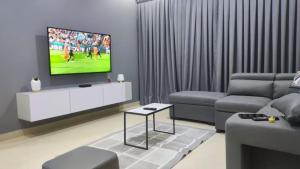 een woonkamer met een bank en een tv bij Modern Haven in Tema