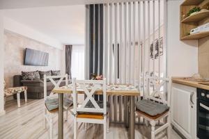 Olivia's Home في سيبيو: مطبخ وغرفة معيشة مع طاولة وكراسي