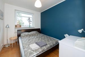 - une chambre avec un lit et un mur bleu dans l'établissement Airport&AtlasArena&OrientariumParking, à Łódź