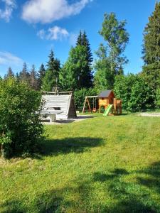 a park with a playground and a house at Camping-Chalets La Favière in Lac des Rouges Truites