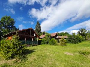 a house with a grassy yard in front of it at Camping-Chalets La Favière in Lac des Rouges Truites