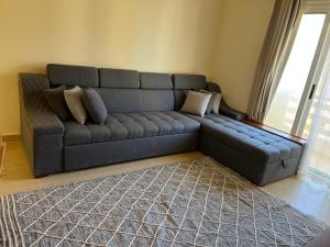 a black couch in a living room with a rug at Lili Home in Ras Sedr +10 photos