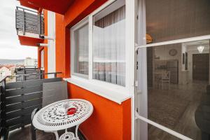 einen Balkon mit einem Tisch und einem Fenster in der Unterkunft Olivia's Home in Sibiu