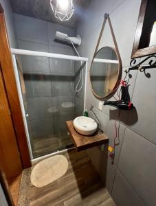 a bathroom with a sink and a mirror at Villa Aconchego Corrêas Itaipava in Petrópolis