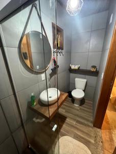 a bathroom with a toilet and a mirror at Villa Aconchego Corrêas Itaipava in Petrópolis