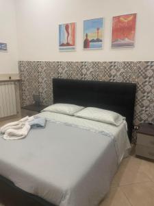 - une chambre dotée d'un lit blanc avec des photos sur le mur dans l'établissement Napoli Home, à Naples