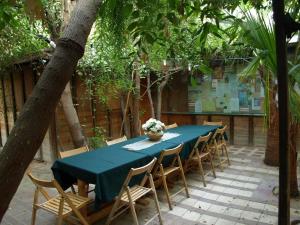 een lange tafel met stoelen en een blauwe tafelkleed bij ערבה גארדן Arava Garden in H̱aẕeva