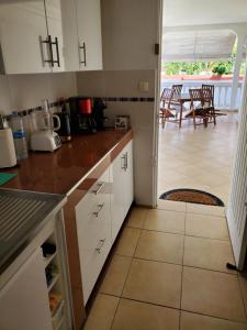 a kitchen with white cabinets and a view of a patio at Villa Iguanina120m2-WIFI-300m plage-4 pers in Le Gosier