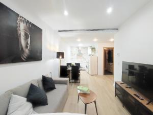 a living room with a couch and a tv at Ohana home 1 in Málaga