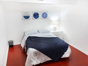 biała sypialnia z łóżkiem z czarnym kocem w obiekcie Spacious 2BR Apartment, Large Kitchen, Parking Included w mieście Mississauga