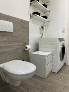 a bathroom with a toilet and a washing machine at Zweizimmerwohnung im Herzen von Quakenbrück in Quakenbrück