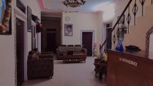 a living room with a person sitting on a couch at Tiger Guest House & Restaurant in Sawāi Mādhopur