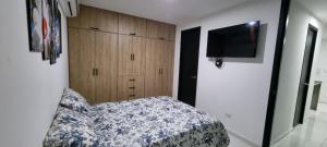 - une chambre avec un lit et une télévision à écran plat dans l'établissement Excelente y cómodo apartamento, vista hermosa y seguridad privada. p7, à Cúcuta