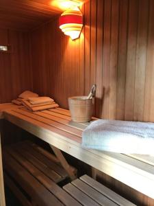 a wooden table in a sauna with a bucket on it at Unser Studio-Apartment "Wohlfühloase" in Oranienburg